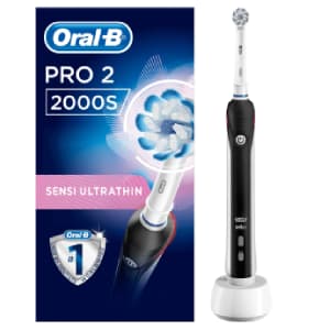 Spazzolino elettrico Oral-b Pro 2 2000S UltraThin nero e bianco su base caricabatteria bianco con a sinistra scatola dello spazzolino su sfondo bianco